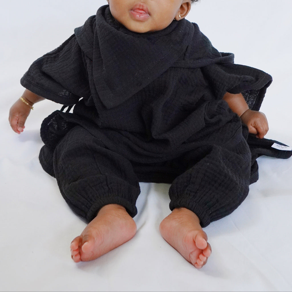 Baby wearing a black outfit on a white background