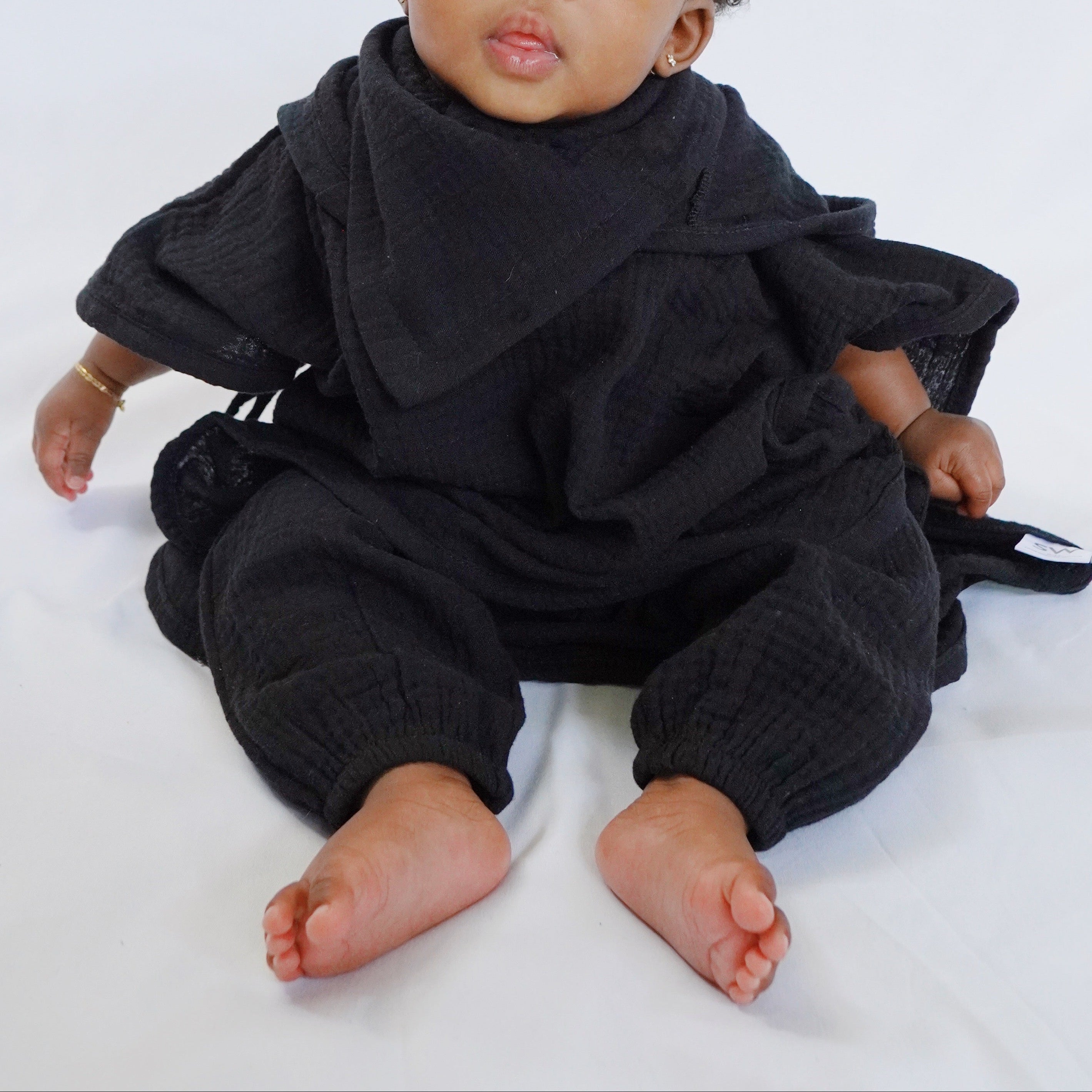 Baby wearing a black outfit on a white background
