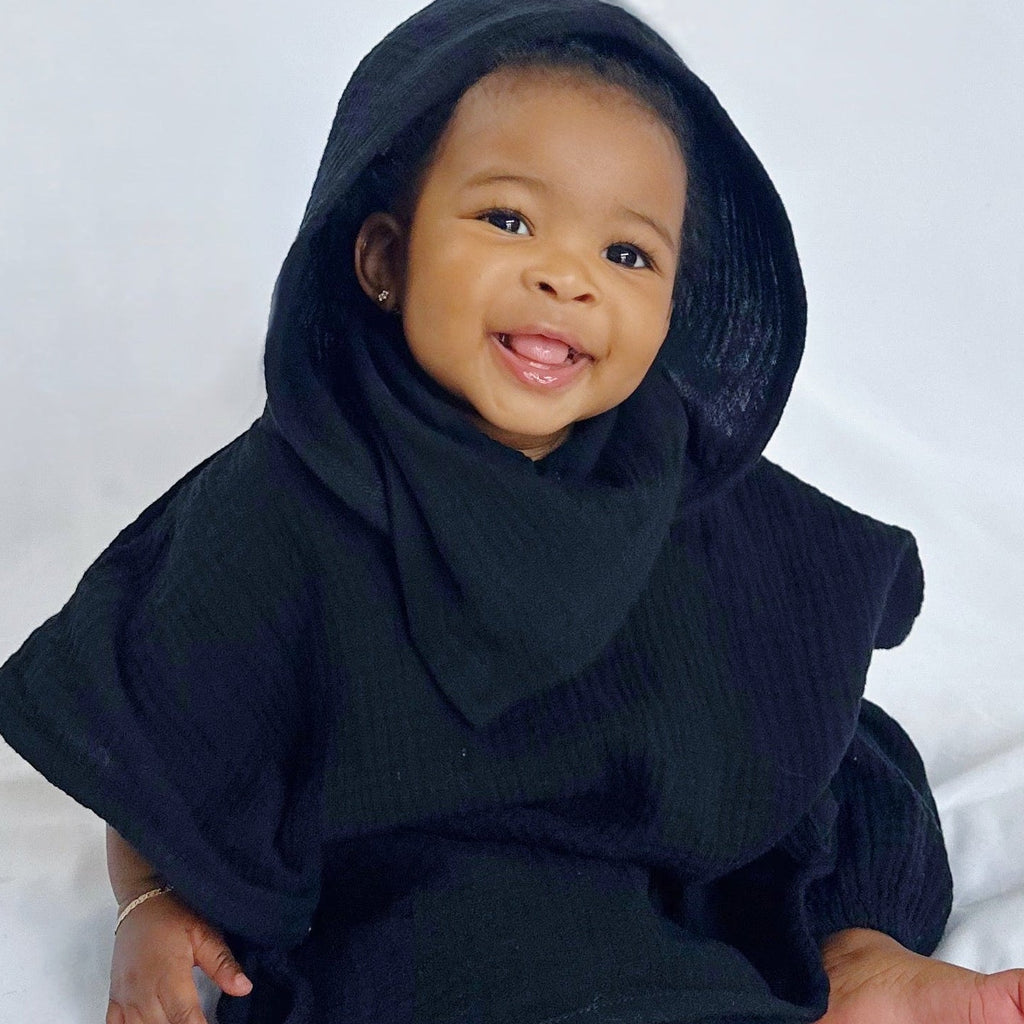 Child wearing a black hooded outfit on a white background