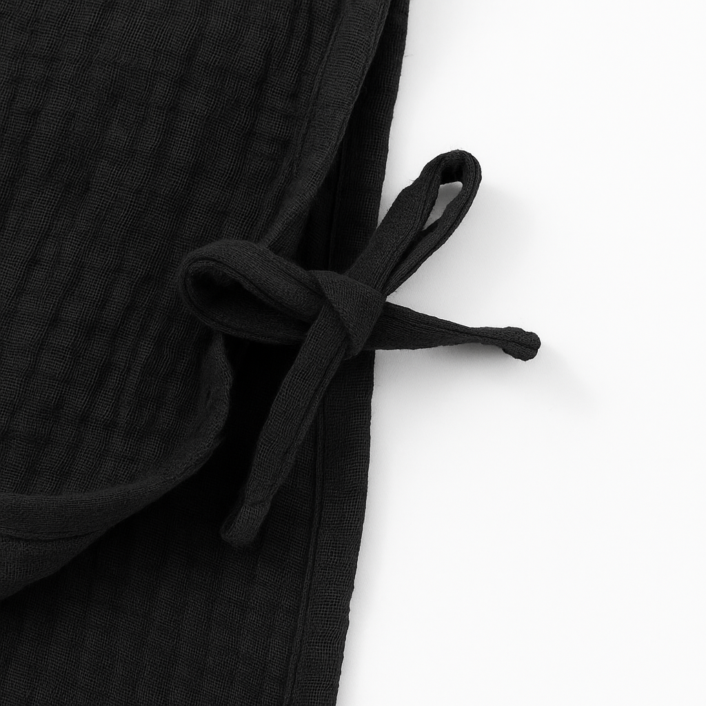 Black textured fabric with a tie on a white background